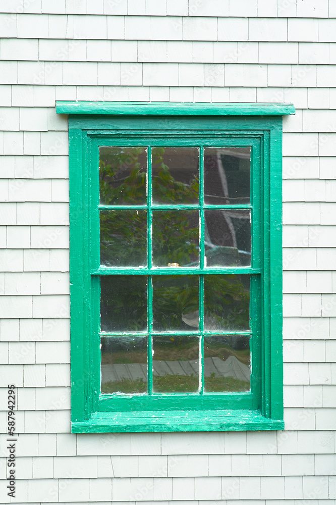 Fototapeta premium Old green window on white wash clapboard shingle house