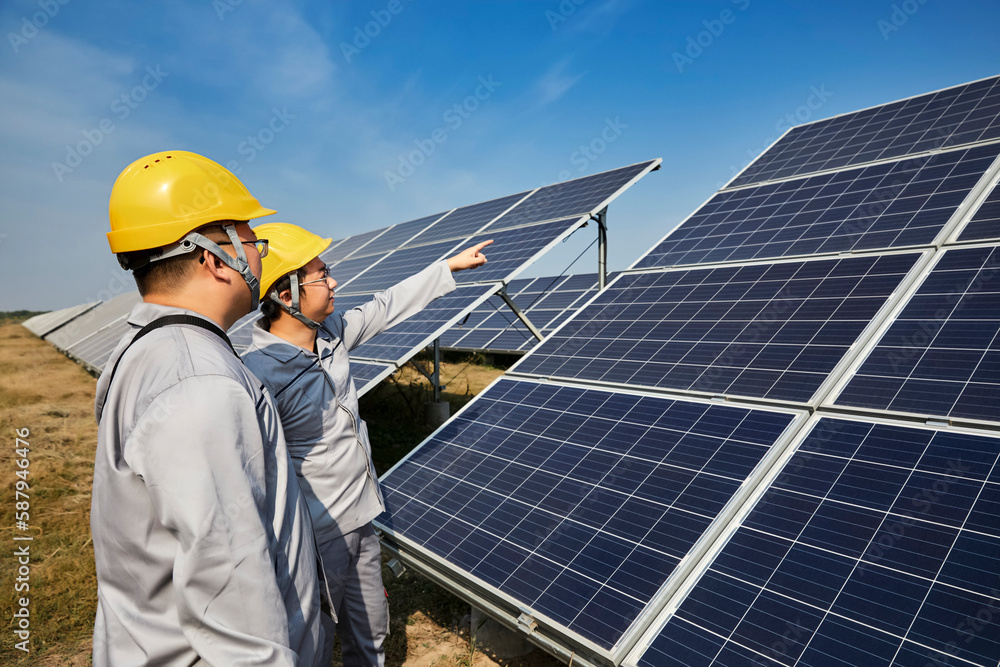 A pair of Asian engineers are inspecting solar photovoltaic power plants outdoors A pair of Asian engineers are inspecting solar photovoltaic power plants outdoors