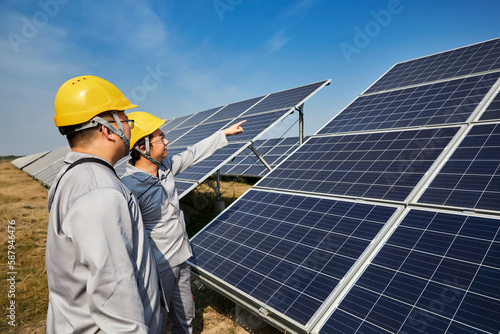 A pair of Asian engineers are inspecting solar photovoltaic power plants outdoors