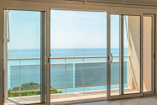 Gorgeous view from the hotel room through the panoramic window to the sea on a sunny warm summer day with blue skies in a luxury resort. Copyspace