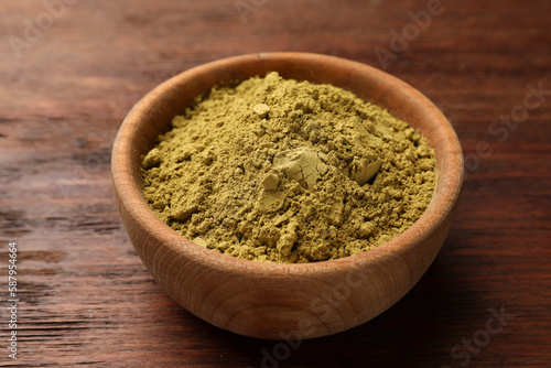 Bowl of henna powder on wooden table © New Africa