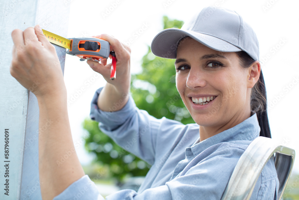 beautiful young woman in overalls with a measuring tape beautiful young woman in overalls with a measuring tape