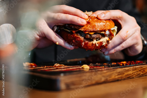 man hands eat fast food burger in pub
