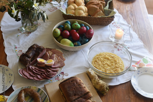 Close-up of Easter breakfast table with traditional slovenian dishes. Ham, colorful eggs, potica and horseraddish. photo