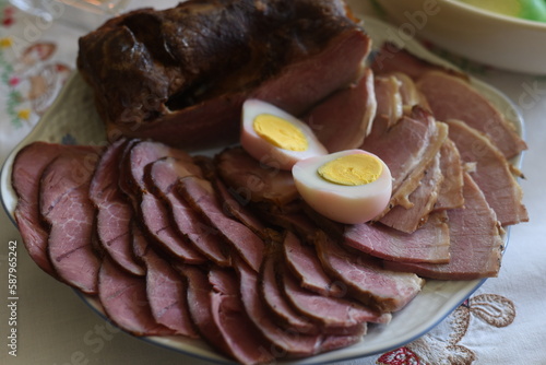 Close-up of Easter breakfast table with traditional slovenian dishes. Ham, colorful eggs, potica and horseraddish.