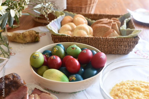 Close-up of Easter breakfast table with traditional slovenian dishes. Ham, colorful eggs, potica and horseraddish.