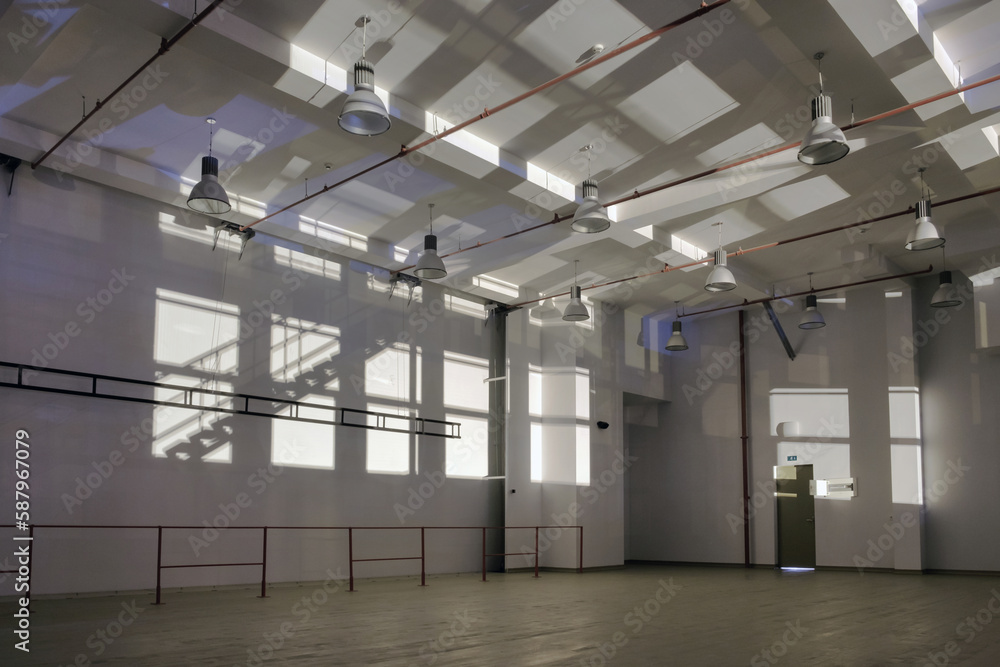 Interior of a large empty space with sun light dropping on the walls Interior of a large empty space with sun light dropping on the walls