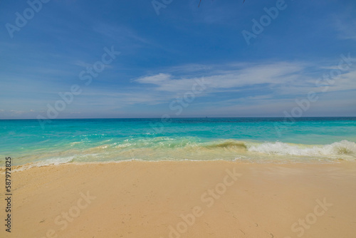 Beautiful nature landscape view of sand beach turquoise water Atlantic ocean surface merging with blue sky. Aruba. 