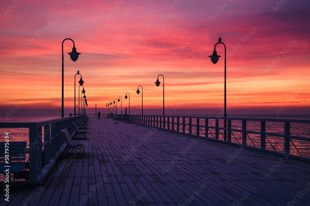 Beautiful sunrise over the Polish sea. Popular pier on the Baltic Sea at sunrise. Photo taken in Gdynia, Poland.