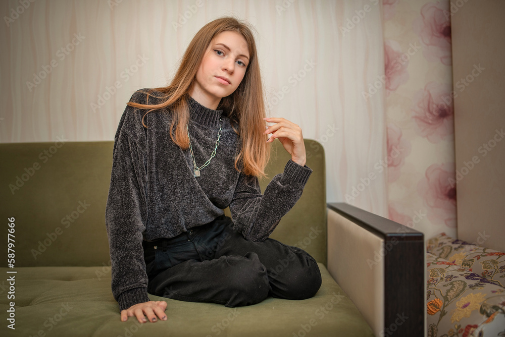 Fototapeta premium Portrait of a young beautiful long-haired girl in a home studio.