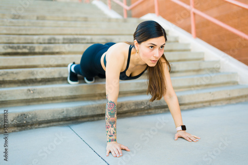 Fitness sporty woman outdoors doing push ups