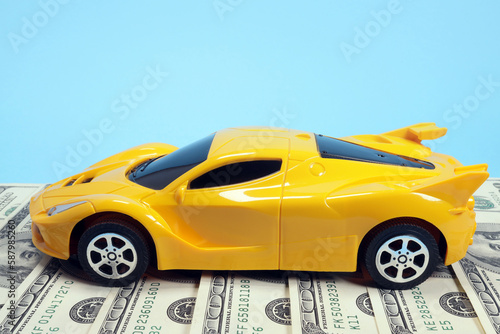 Toy car on dollars  cost concept  auto insurance