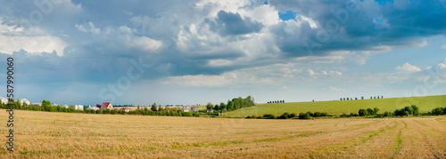 Panoramic view of wheat fields, straw stubble in foreground, hills, green soy...