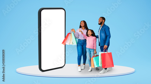 Shocked excited glad young african american family and small girl hold shopping bags pointing finger