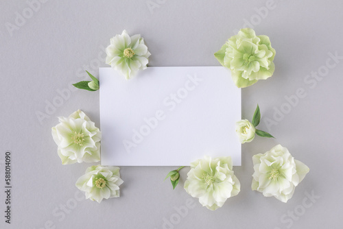 Invitation card mockup with empty paper blank decorated natural flowers top view. Minimal aesthetic template.