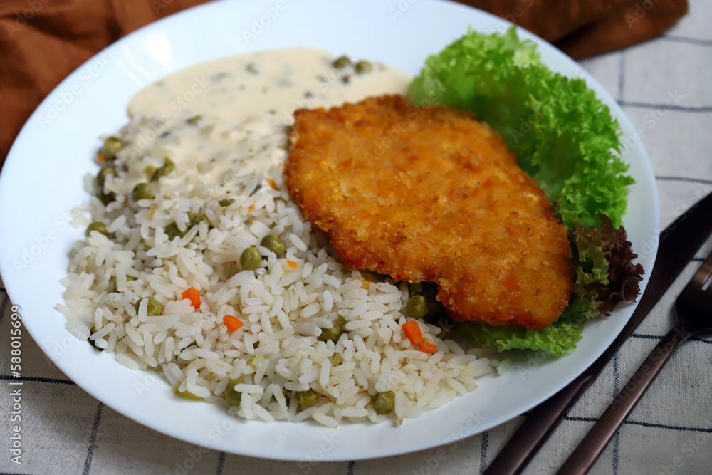 Rice with vegetables and chicken schnitzel. Healthy lunch or dinner on a plate. Rice with vegetables and chicken schnitzel. Healthy lunch or dinner on a plate.