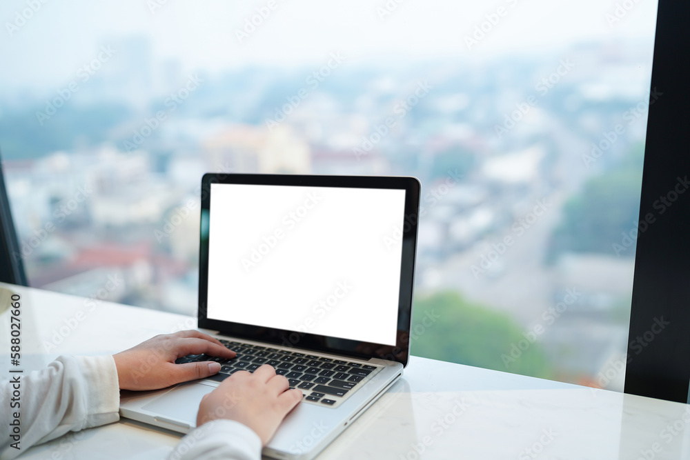 Woman Working by using laptop blank screen computer . Hands typing on a keyboard.technology e-commerce concept.