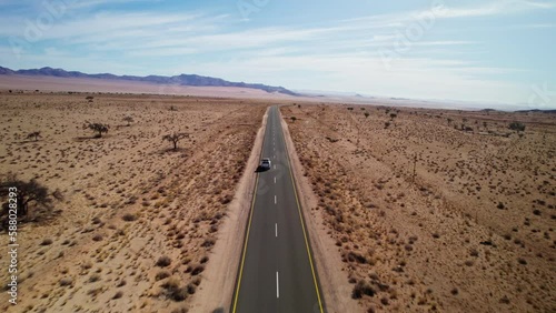 Car driving on the road in a Namib desert, Namibia. View from drone photo