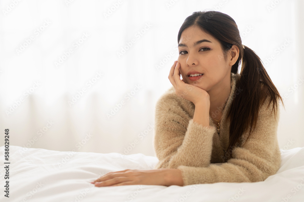 Portrait of smiling cheerful beautiful pretty asian woman clean fresh healthy white skin posing smile in in warm knitted clothes.Girl felling relax and enjoy time on the bed at home.asia beauty Portrait of smiling cheerful beautiful pretty asian woman clean fresh healthy white skin posing smile in in warm knitted clothes.Girl felling relax and enjoy time on the bed at home.asia beauty
