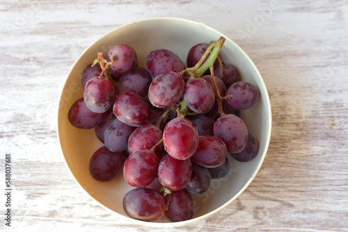 bunch of red grapes on wooden table photo