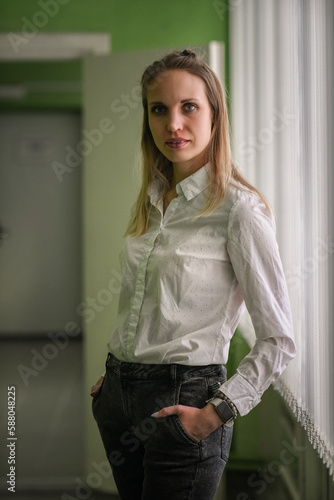 Portrait of a young beautiful long-haired girl in an interior studio with natural light.