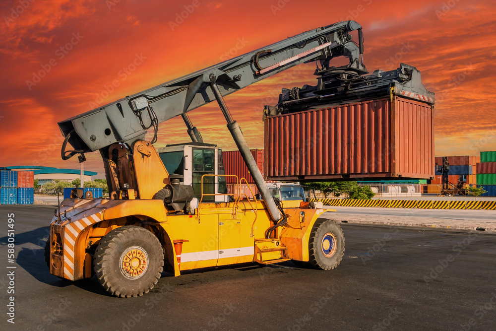 Crane lifting up container in yard.