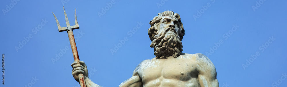 Close up the mighty god of sea and oceans Neptune (Poseidon) The ancient statue against bleu background.. Horizontal image.