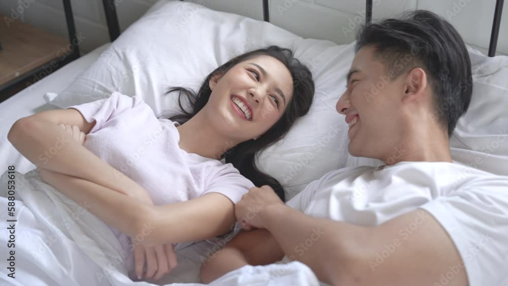 Happy young Asian couple hugging and laughing in bedroom. Happy young Asian couple hugging and laughing in bedroom.