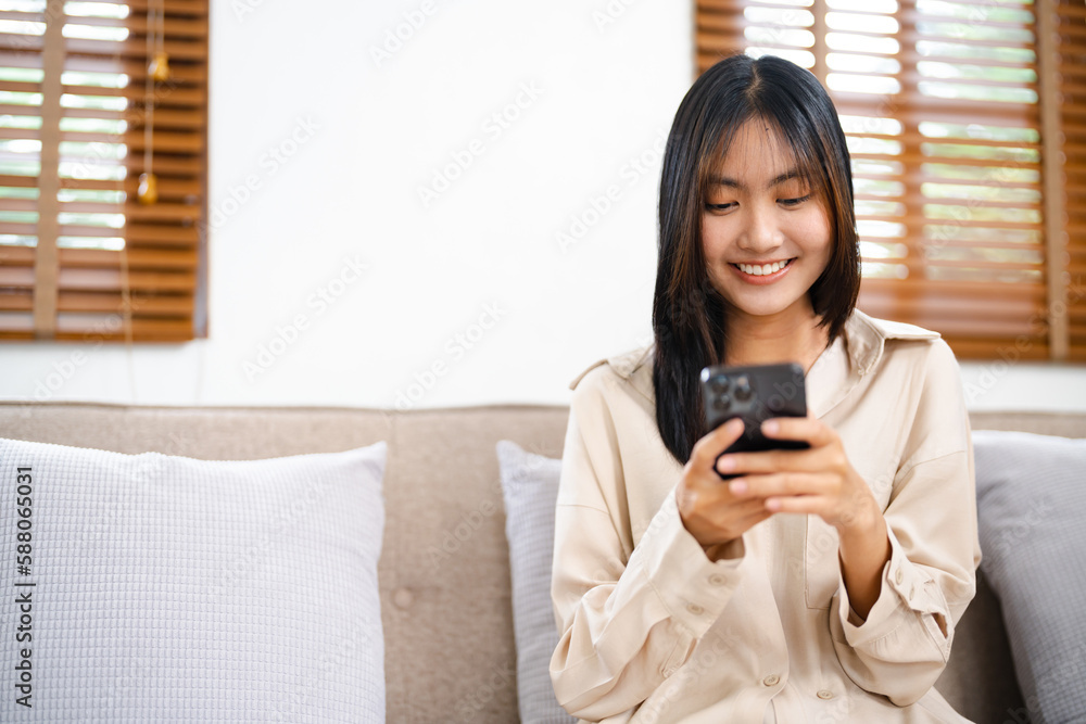 Asian girl using cell phone for checking social media at home holding smartphone in morning. Asian girl using cell phone for checking social media at home holding smartphone in morning.