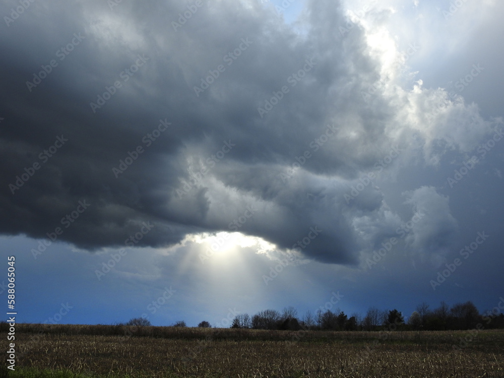 Storm clouds with rays of sunshine beaming down upon a field in Cecil County, Maryland.