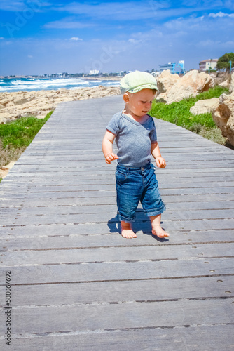 a happy child walks along the path on the nature by the sea photo