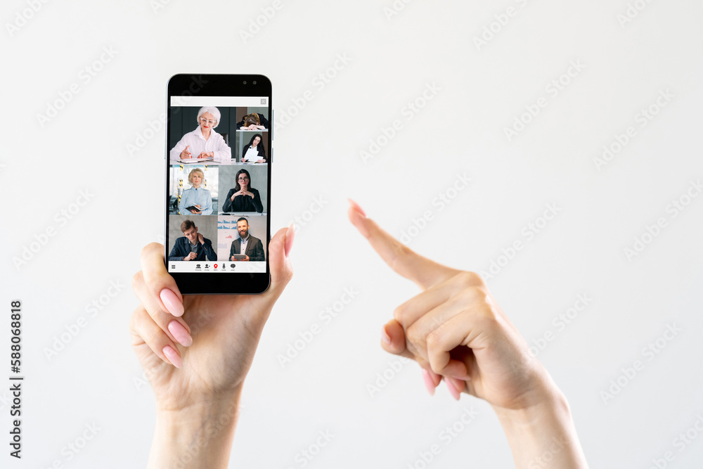 Mobile conference. Video call. Internet communication. Female hand pointing at professional business team working online on phone screen on white copy space.