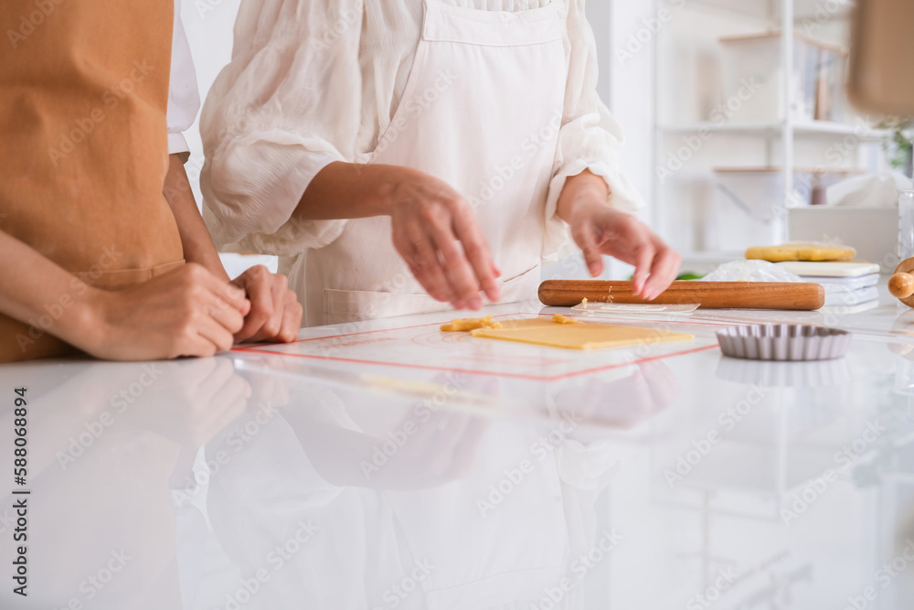 Women making bakery with rolling pin together. Women making bakery with rolling pin together.