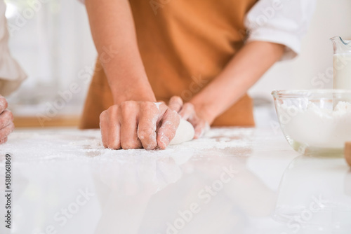 Woman kneading dough on the table.