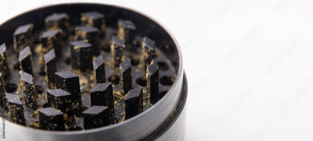 Mill for tobacco. grinder with marijuana close-up on a white background with copy space. selective focus Mill for tobacco. grinder with marijuana close-up on a white background with copy space. selective focus