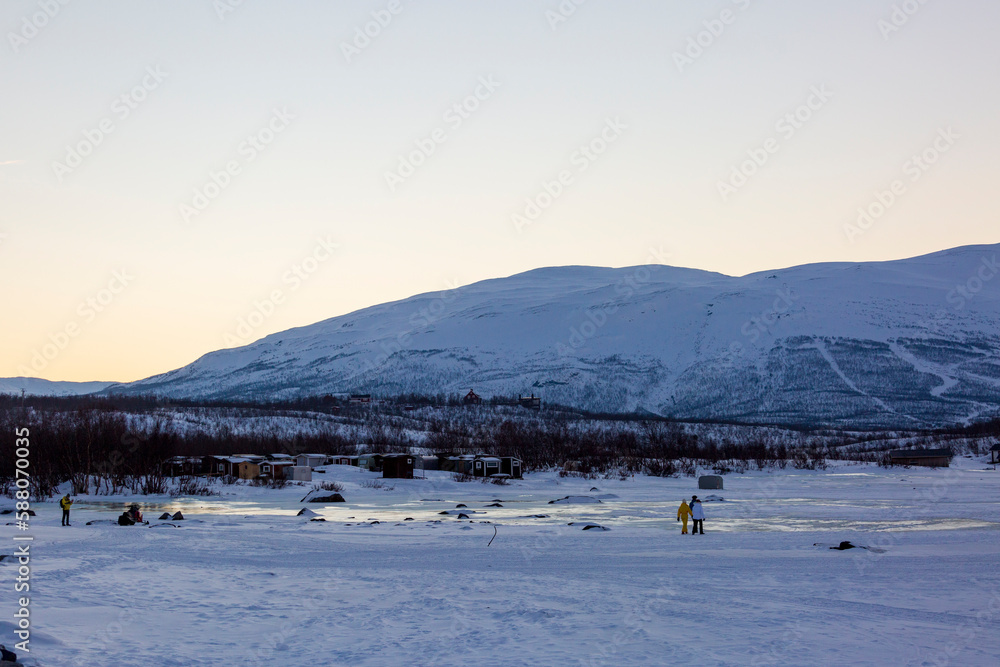 Abisko in Lapponia in Svezia. Tramonto al lago di Tornetrask ghiacciato. Sole, neve, ghiaccio, al circolo polare artico, un paesaggio del nord Europa