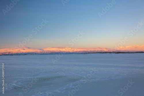 Abisko in Lapland in Sweden. Sunset at frozen Tornetrask Lake. Sun, snow, ice, the Arctic Circle, a landscape of northern Europe