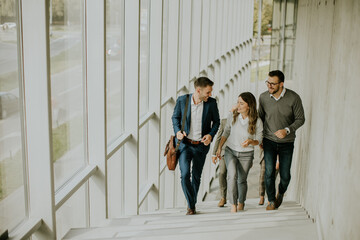 Group of corporate business professionals climbing at stairs in office corridor