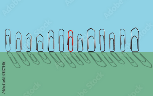 Still-life with one red paperclip among others metal paperclips