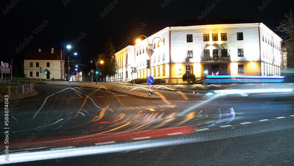 Obraz premium Night city light lines from cars. cars in highway with blur motion. Street view of the modern city at night. A lot of light from car headlights, advertising banners and night lights.