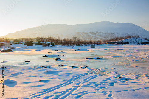 Abisko in Lapponia in Svezia. Tramonto al lago di Tornetrask ghiacciato. Sole,neve,ghiaccio,al circolo polare artico,un paesaggio del nord europa photo