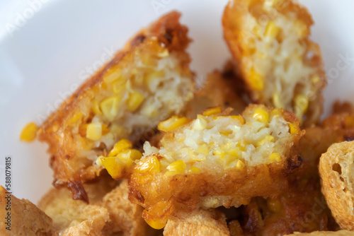 Deep fried sweet corn on white plate usually serving with peanut sweet and sour dipping sauce.