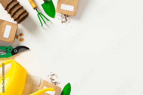 Gardening tools, peat pots, seeds packets, watering can on white background. Spring garden works concept.