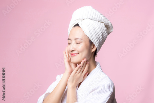 Bild auf Leinwand Beautiful young asian woman happy with clean face skin in towel and bathrobe, spa suit on pink background