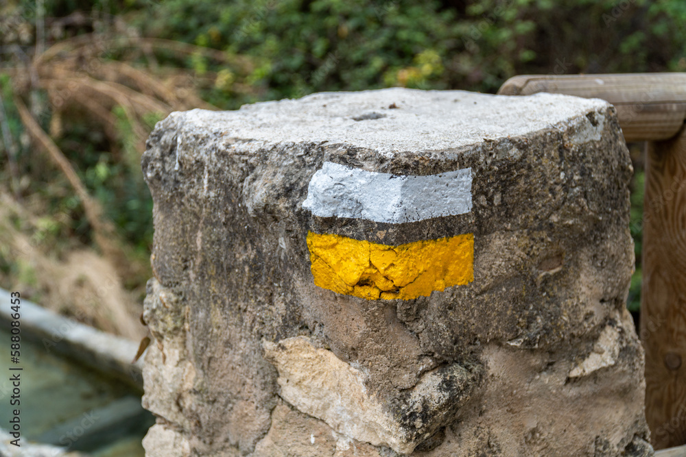 Obraz premium Striped lines in yellow and white, orientation sign to hikers
