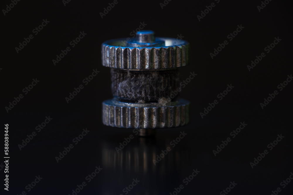 Close up small used steel wheel from firestarter on black background Close up small used steel wheel from firestarter on black background