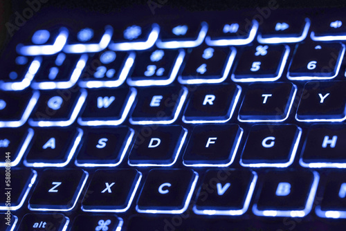 Macro closeup of electronic LED back lit keyboard  blue and white lighting 