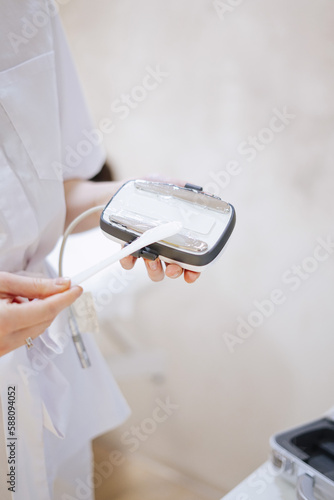 close up of a person holding a appliance for beauty treatment