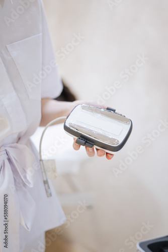 close up of a person holding a appliance for beauty treatment
