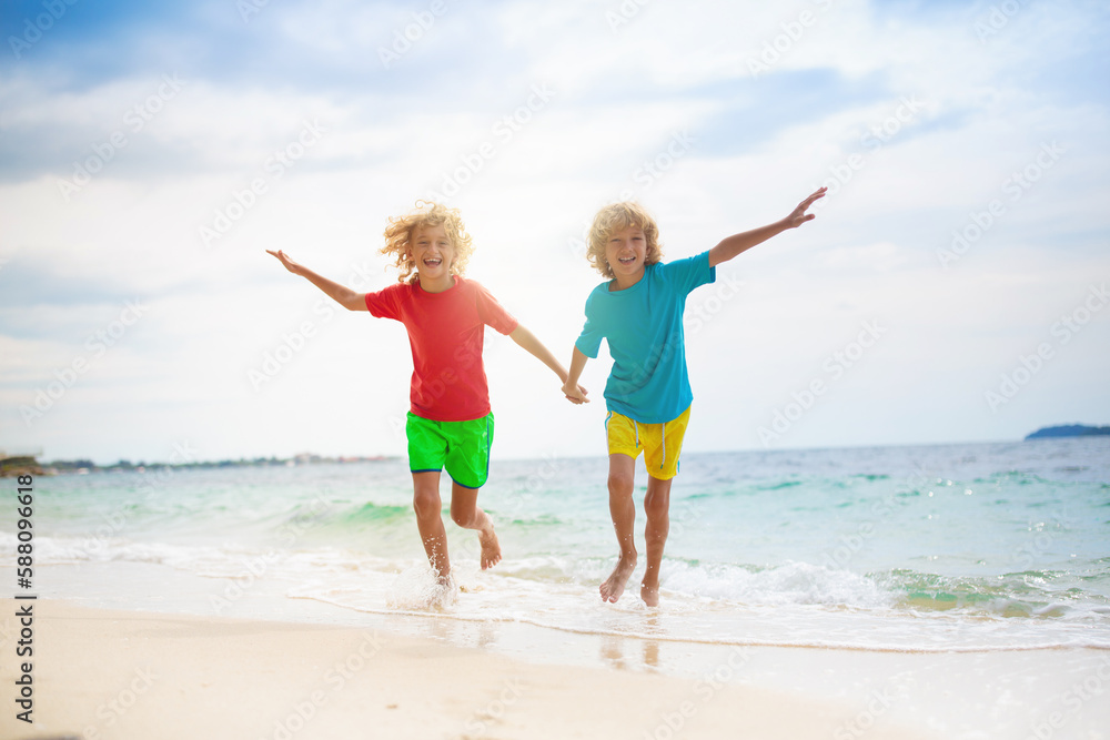 Kids on tropical beach. Children playing at sea.